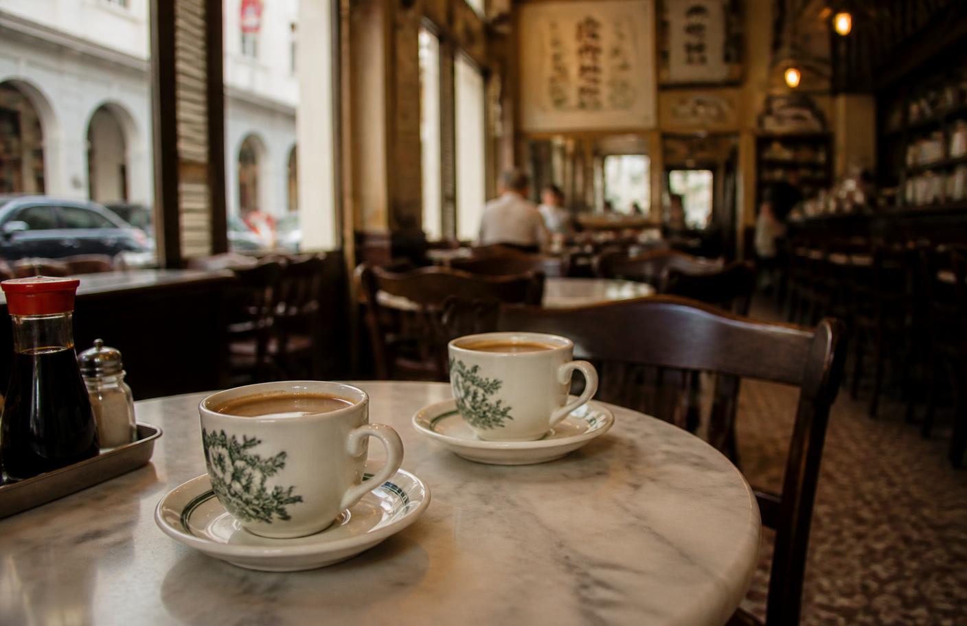 Two cups of kopi on a marble table in a traditional Singapore kopitiam